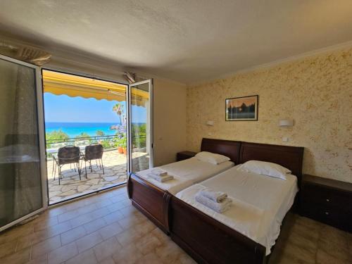 een slaapkamer met een bed en uitzicht op de oceaan bij Corfu Glyfada Beach Apartment 45 in Glyfada