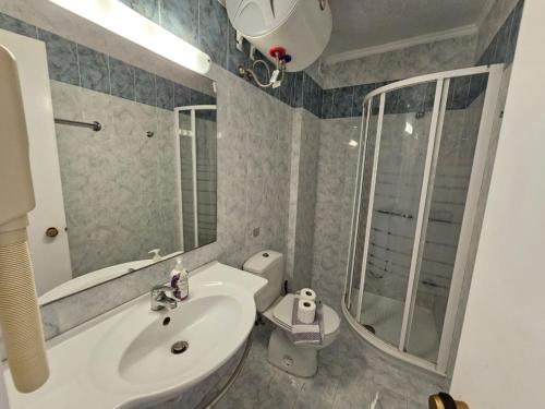 a bathroom with a sink and a toilet and a mirror at Corfu Glyfada Beach Apartment in Glyfada