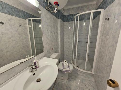 een badkamer met een wastafel, een toilet en een douche bij Corfu Glyfada Beach Apartment 45 in Glyfada