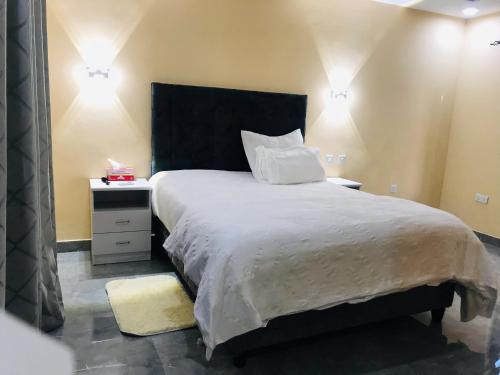 Schlafzimmer mit einem großen Bett mit einem schwarzen Kopfteil in der Unterkunft Batoka Apartments in Lusaka