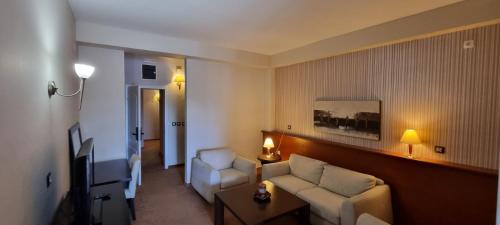 a living room with a couch and a tv at Hotel Bluebell in Ohrid