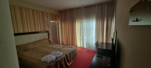 a hotel room with a bed and a window at Hotel Bluebell in Ohrid