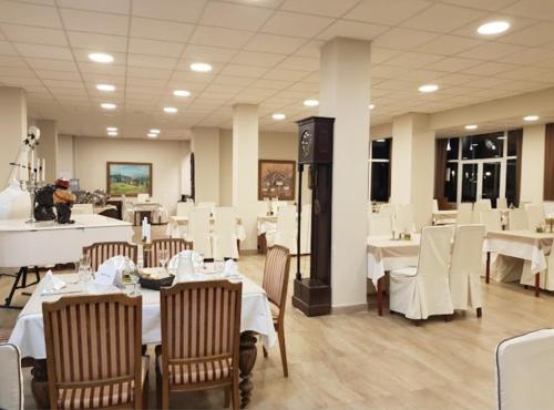 a dining room with white tables and white chairs at Hotel Bluebell in Ohrid