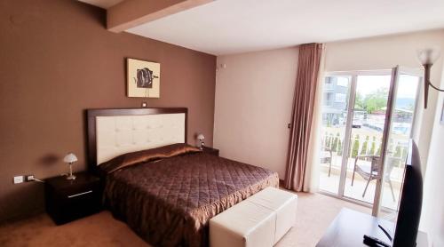 a bedroom with a bed and a sliding glass door at Hotel Bluebell in Ohrid