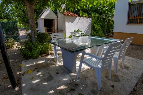 een glazen tafel en stoelen op een patio bij Les Olles Riumar Pura Natura in Riumar