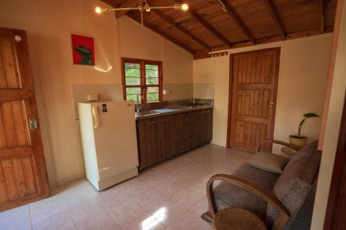 eine Küche mit einem Kühlschrank und einem Sofa darin in der Unterkunft Alma Hotel Campestre in Santa Elena