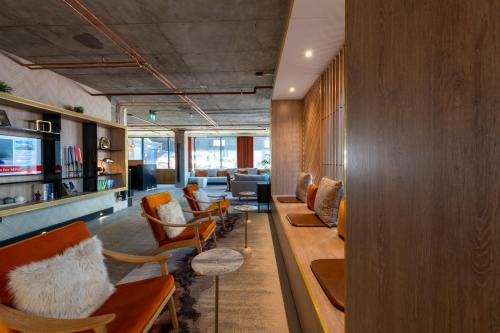 a lobby with chairs and tables and a waiting room at Sandman Signature Glasgow Hotel in Glasgow