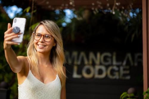 a woman taking a picture with her cell phone at Manglar Lodge in San Carlos