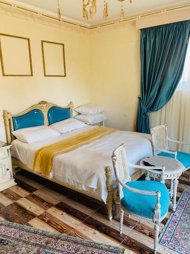 a bedroom with a large bed and two chairs at Lovely Villa 5- bedroom with Overflow Pool with Nice Garden at Green Oasis Resort in Alexandria