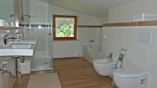 e bagno con servizi igienici, lavandino e doccia. di Brandtnerhof Betriebe a Waidring
