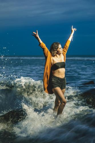 a woman jumping in the water in the ocean at Manglar Lodge in San Carlos