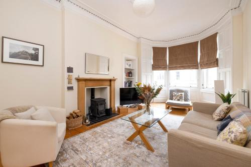 uma sala de estar com um sofá e uma lareira em Tasteful 1-bedroom Apartment near Edinburgh Meadows em Edimburgo