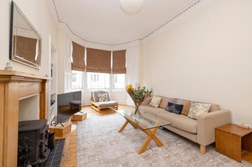 a living room with a couch and a fireplace at Tasteful 1-bedroom Apartment near Edinburgh Meadows in Edinburgh
