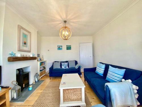 uma sala de estar com sofás azuis e uma lareira em 83 Gills Cliff Road em Wroxall