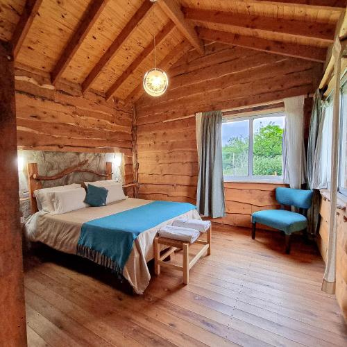 a bedroom with a bed in a log cabin at Cabañas del Espinillo in Villa General Belgrano