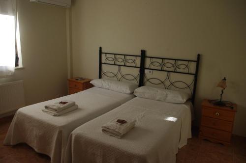a bedroom with two beds with white sheets and towels at Hotel la Hoja*** in Aldeadávila de la Ribera