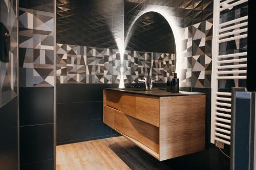 uma casa de banho com azulejos pretos e brancos e um lavatório. em LA MAISON CACHEE-BA em La Teste-de-Buch