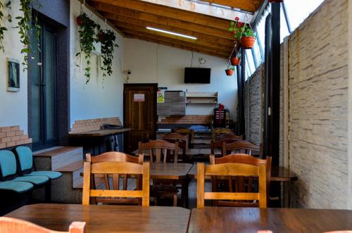 an empty restaurant with wooden tables and chairs at ROMSIL GUESTHOUSE in Costinesti