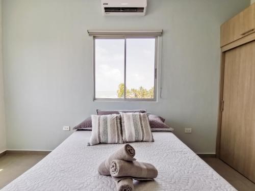 1 dormitorio con 1 cama con toallas en Dúplex de lujo con vista al mar, en San Bernardo del Viento