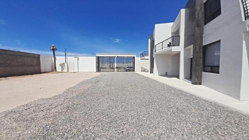 a white building with a gate and a driveway at New Town Condo Casamar 4 near the beach in Puerto Peñasco