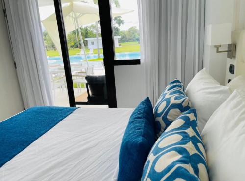 a bedroom with a bed with blue and white pillows at rock star B101 in Punta Cana