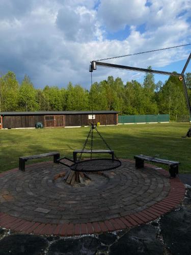 a playground with two benches and a swing at Letnia Oaza "Akacja" in Sobienie Jeziory