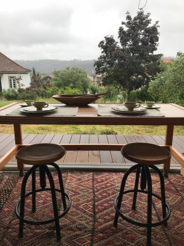 a table and two stools sitting on a patio at Adore Portugal Bungalow Natureza & Vista de Serra in Lousã