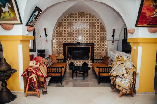 uma sala de estar com lareira e cadeiras em DAR BELDI em Hammamet