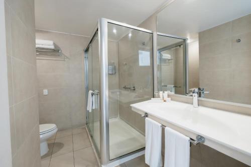 a bathroom with a shower and a sink and a toilet at Terrado Suites Iquique in Iquique