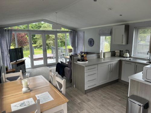 eine Küche und ein Esszimmer mit einem Tisch und einem Esszimmer in der Unterkunft Orchard View Lodge in Woodhall Spa