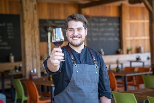 a man is holding up a glass of wine at Hotel Ryzlink in Mikulov