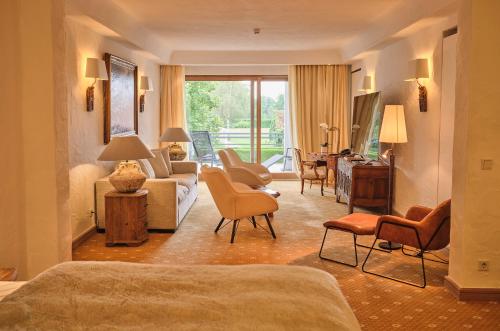 a bedroom with a living room with a couch and chairs at BLEICHE RESORT & SPA in Burg