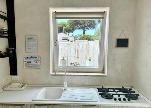 a kitchen counter with a sink and a window at CASA MILA in Marina di Cerveteri