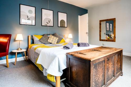 a bedroom with a bed with a wooden dresser at The Tigers Townhouse in Leicester