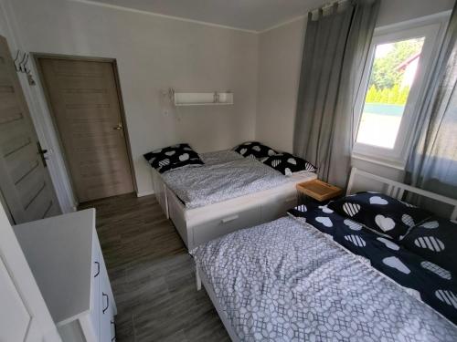 two beds in a small room with a window at NASZE 4 KĄTY in Junoszyno