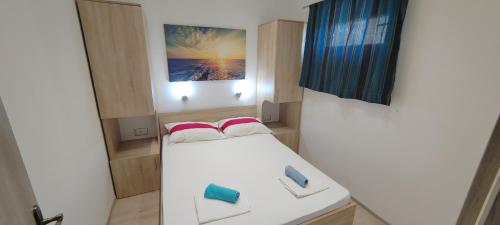 a small room with a bed and a sink at Apartmani ANDRIJA in Živogošće