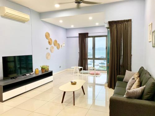 a living room with a couch and a tv and a table at Deco Home @ Imago The Loft in Kota Kinabalu