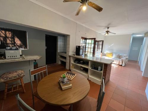 Casa Bravo - Pilgrims Palace في بريتوريا: غرفة معيشة مع طاولة ومطبخ