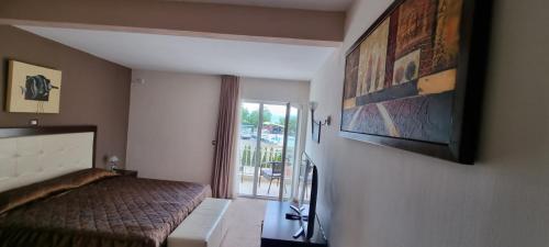 a bedroom with a bed and a large window at Hotel Bluebell in Ohrid