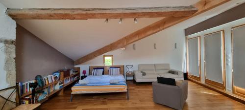 ein Wohnzimmer mit einem Bett und einem Sofa in der Unterkunft Au vieux four à pain - Studio à louer in Chevry