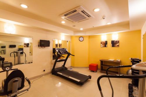 a room with a gym with a treadmill and a mirror at Ginger Indore in Indore
