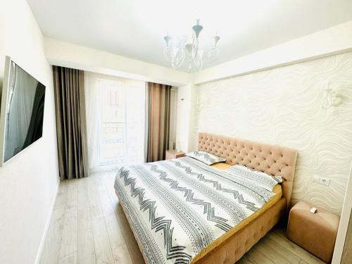 a bedroom with a bed and a chandelier at 2-х комнатная квартира #Inamstro Apartament cu 2 camere cu TERASA in Chişinău