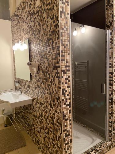 a bathroom with a shower with a sink and a mirror at B&B Porta Baresana in Bitonto
