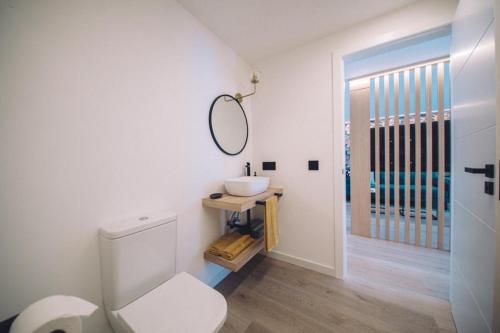 ein Badezimmer mit einem weißen WC und einem Waschbecken in der Unterkunft Casa playa Las Sinas in Vilanova de Arousa