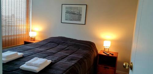 1 dormitorio con 1 cama con 2 toallas en Departamento Vista Cordillera, en Santiago