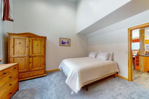 a bedroom with a bed and a wooden cabinet at Spruce Way Retreat in Vail