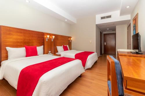 a hotel room with two beds and a television at Hotel Faranda Express Puerta del Sol Porlamar in Porlamar
