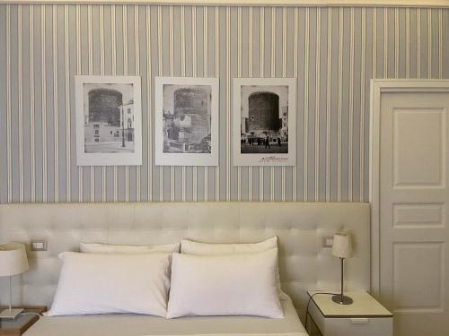 a bedroom with a bed with three pictures on the wall at B&B Porta Baresana in Bitonto