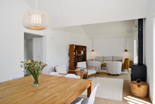 a living room with a wooden table and a dining room at Sobreiras Alentejo Country Hotel - by Unlock Hotels in Santa Margarida da Serra