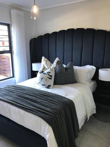 a bedroom with a large bed with a black headboard at Haven Sanctuary in Avalon